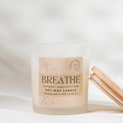 Candle with a 'Breathe' label on a soft white background