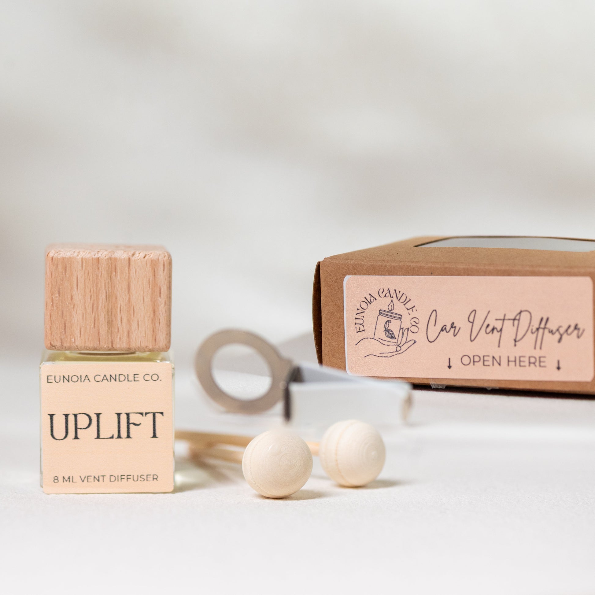 Eunica Candle Co. Uplift car diffuser bottle with packaging on a light background