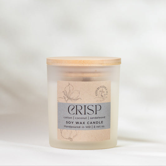 Candle with a wooden lid and 'CRISP' label on a light background