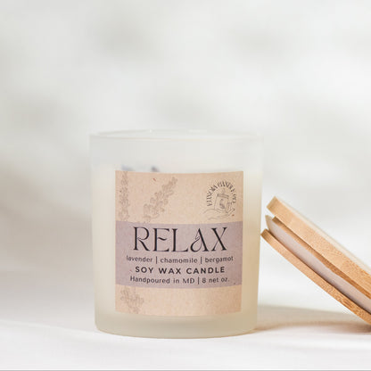 Candle with 'relax' on kraft paper label and a wooden lid on a white background