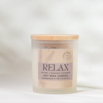 Scented candle labeled 'Relax' on a soft white background