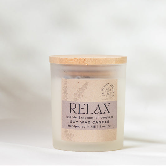 Scented candle labeled 'Relax' on a soft white background