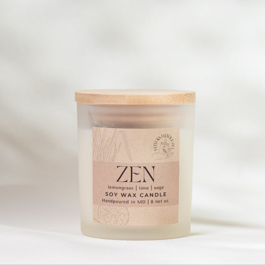 Candle labeled 'Zen' with a wooden lid on a soft white background